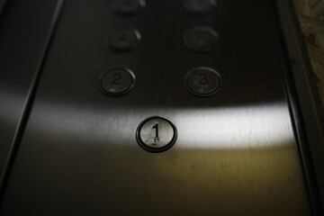 Close-Up of Elevator Button Panel with Number One in Focus on Metallic Surface