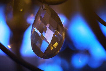 Close-up of Faceted Crystal Pendant with Abstract Blue Bokeh Background