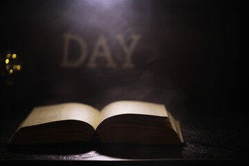 Open Book with Glowing Light in Dark Room Creating Artistic Shadows in the Background