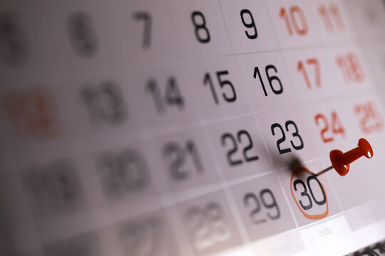 Close-up of Desk Calendar with Red Push Pin Marking the 30th Day of the Month