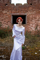 Portrait of a person. Woman's gaze. Face. Red manicure. Ruins of an old house. A young woman in a white dress. Portrait of a girl. Graceful figure. 