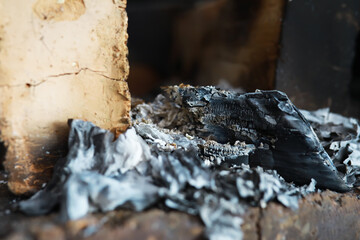 Burnt Wood and Ashes: Close-Up of Charred Remains in a Fireplace after a Fire