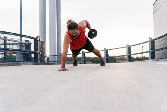 Young man training with dumbbell