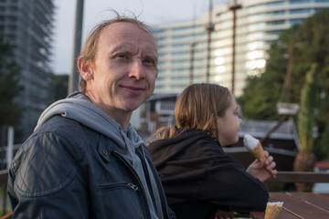 Happy man sitting in caffee with her child girl, outdoors portrait