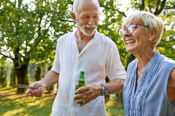 Happy senior couple having a barbecue in garden