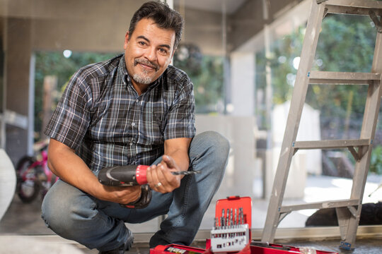 Portrait of smiling man with portable drill