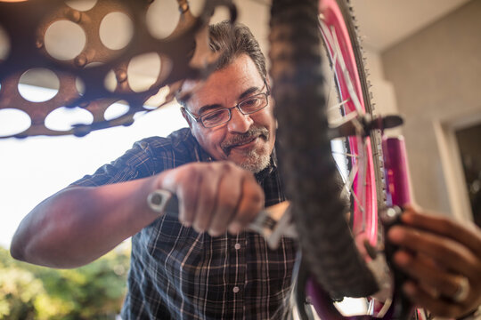 Man fixing wheel of children's bicycle