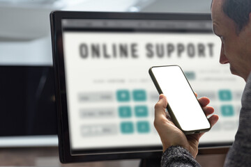 Angry man talking with call center helpdesk in front of computer screen. Male consumer seated at a computer, viewed from behind, engaged in online communication with support services on the monitor