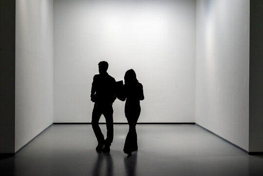 Silhouette di coppia umo, donna in stanza bianca e vuota.