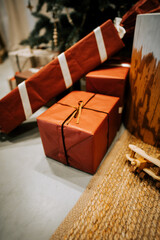Festive Holiday Gifts Wrapped in Vibrant Red Decor Placed Near a Beautifully Decorated Christmas Tree in a Cozy Indoor Setting