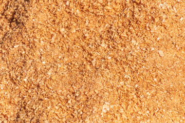 A close-up of fine, freshly cut golden sawdust.