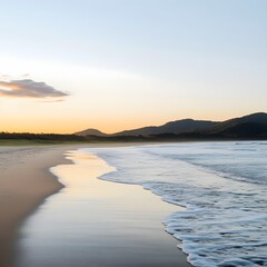 A photo of a tranquil beach at sunrise, with gentle waves washing over smooth, golden sand.
