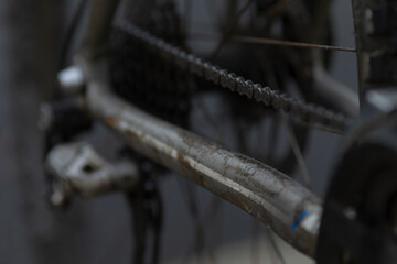 This is a closeup image showing the intricate details of a bicycle chain situated on a road surface, capturing its essential mechanics