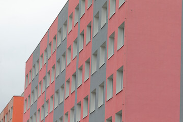 The structure features a combination of red and gray colors and is characterized by numerous windows, offering a modern aesthetic