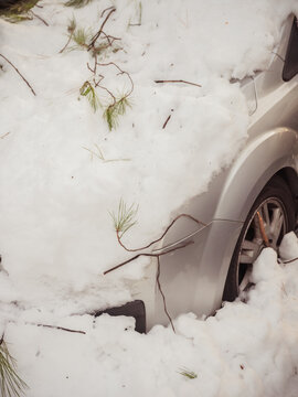Winter storm covers car in snow on city street
