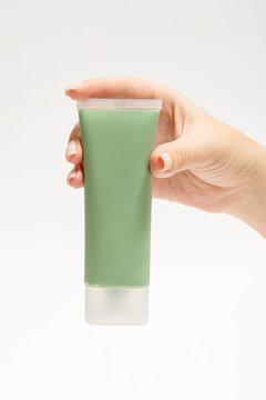 Green face mask held in hand for beauty and skincare