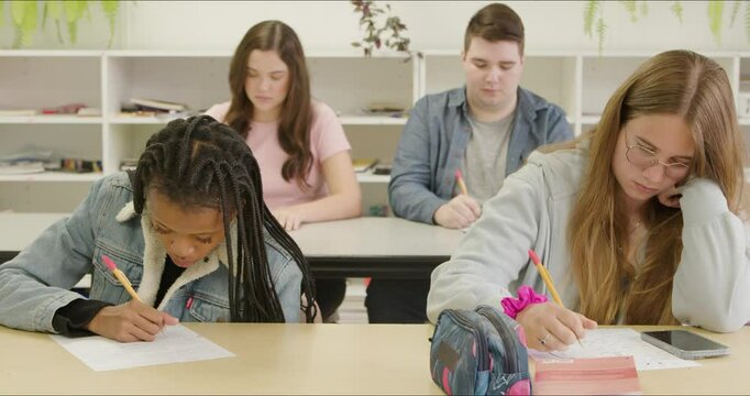 Student Writing Mid Terms Final Exams Test Peaks to Cheat on Answers. College Students Group Project. Academic Studies. Diverse Female Students Write Notes, Study in Class. Back to School