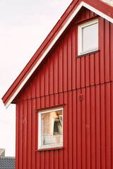 Small red cabin in a lush forest by a Norwegian lake