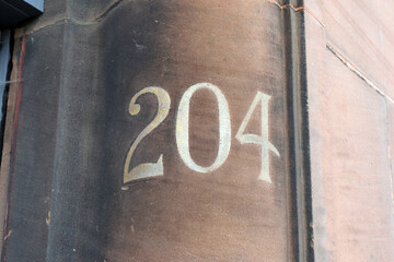 Hand Painted Address Number 204 on Curved Stone Entrance to Old Building