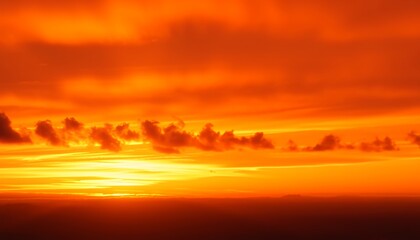 Obraz premium A stunning sunset over the ocean. Intense orange hues dominate the sky, creating a mesmerizing scene. The calm water reflects the vibrant colors.