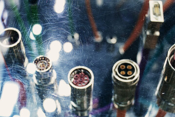 Blurred industrial background with cable connectors and scratches on glass.