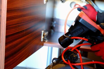 A plumber is trying to open a clogged bathroom pipe using a camera system. Close-up view of opening...