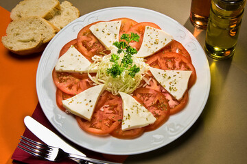 Ensalada de tomate con queso fresco y repollo rallado.