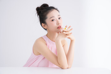 ピンク色のネイルをした美しい若い女性のスウィートなポートレート