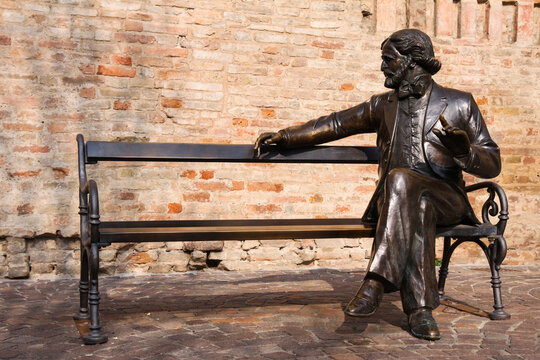 Giuseppe Verdi's iconic bronze statue resting on a bench, symbolizing his contributions to classical music and opera, attracting visitors worldwide.