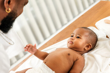 A tender moment between a father and his baby, showcasing love and connection in a bright, serene...