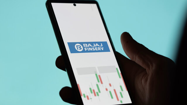 An investor analyzing the bajaj finserv etf fund on a screen. A phone shows the prices of Bajaj Finserv