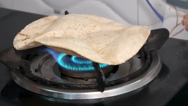 Cooking Indian style chapati on gas flame. 