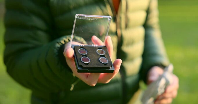Close-up of hand presenting drone camera filter kit in compact case