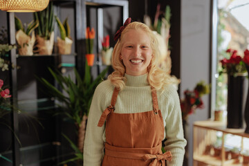 Happy florist in a plant-filled shop