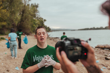 Videographer filming volunteer with down syndrome cleaning beach © bernardbodo