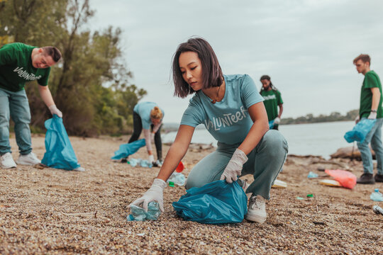 Volunteers picking up trash on a riverbank: promoting environmental awareness