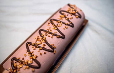 A decadent chocolate Buche de Noel decorated with zigzag chocolate drizzle and golden caramelized...