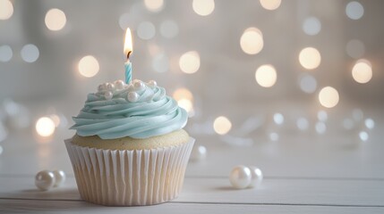 Elegant Blue Cupcake with Lit Candle and Pearl Decorations on Bokeh Background