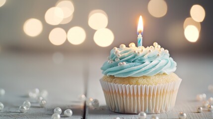 Elegant Blue Cupcake with Lit Candle and Pearl Decorations on Bokeh Background