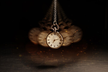Hypnosis session. Vintage pocket watch swinging on black background, motion blur effect. Magic lights