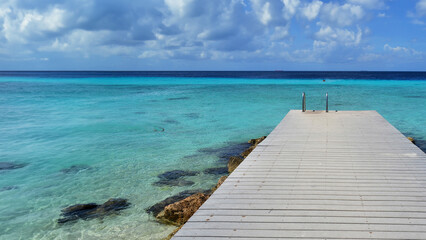 a pier on a beach on an island in the caribbean sea