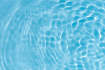 Blue water with ripples on the surface. Defocus blurred transparent blue colored clear calm water surface texture with splashes and bubbles. Water waves with shining pattern texture background.