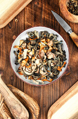 Dried mushrooms pile on a wooden table.