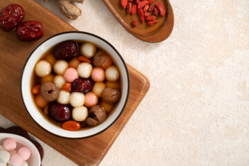 Red and white tangyuan with syrup soup, dried longan pulp, red dates for Winter solstice.