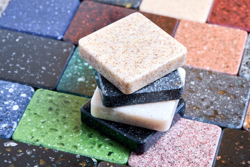 Porcelain stoneware artificial stone square samples as kitchen countertop examples of future kitchen fasade exterior. Samples slabs of natural granite marble quartz for stone countertops close up.