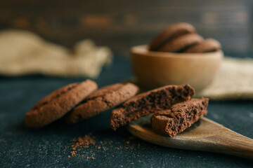 Chocolate brownie cookies on wooden spoon, sweets background