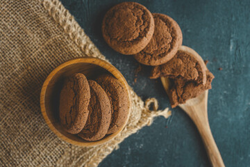Chocolate brownie cookies on wooden spoon, sweets background