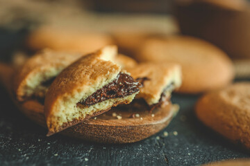 Chocolate brownie cookies on wooden spoon, sweets background
