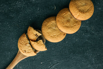Shortbread cookies with chocolate filling on a wooden spoon, background sweets