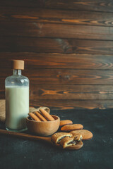 Homemade with chocolate filling on a wooden spoon and a bottle of milk, good morning